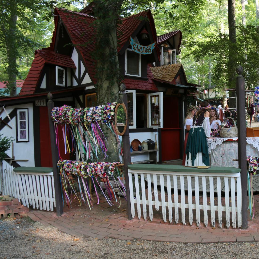 Festival grounds with a cottage and traditionally dressed women
